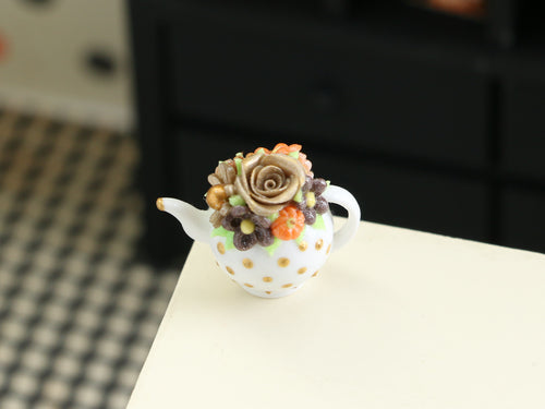 Teapot-shaped cake with floral design on a white surface