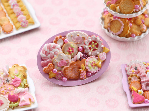 Assortment of Pink-Themed Miniature Cookies and Treats on Oval Tray