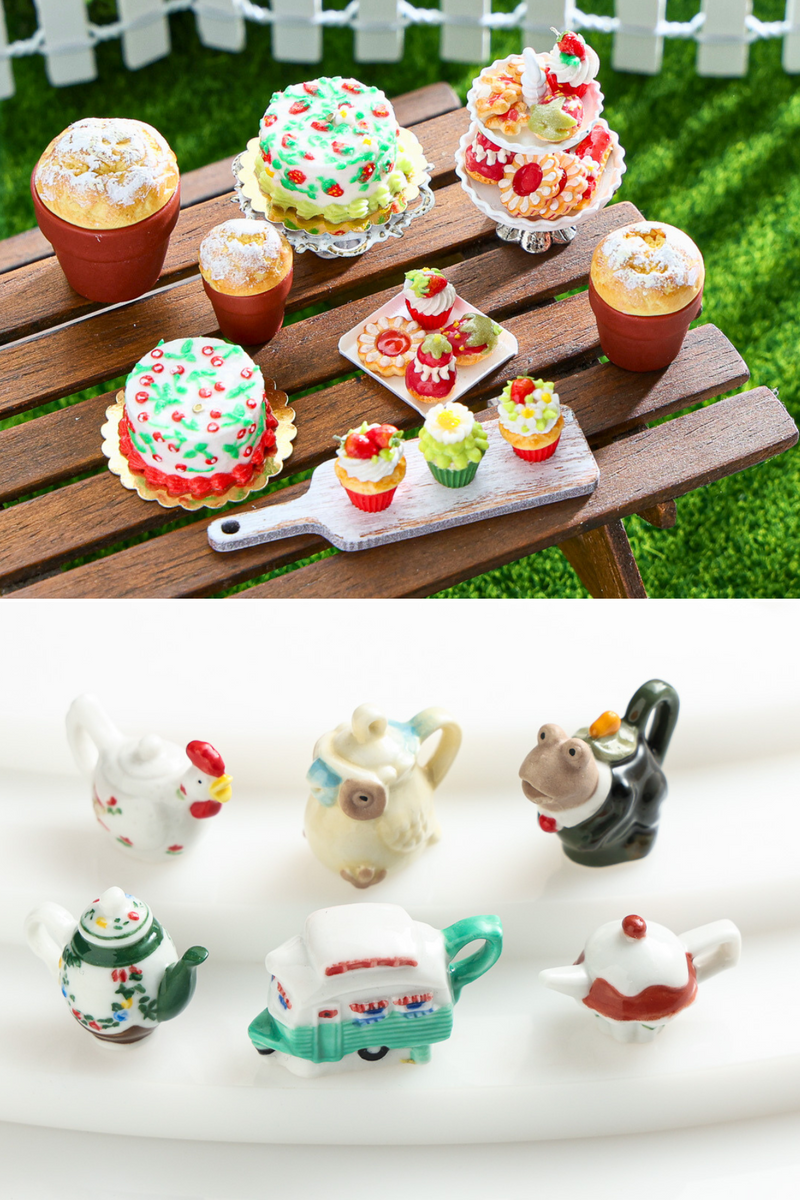 Strawberry themed collection of miniature pastries on a miniature picnic table and a collection of whimsical miniature teapots