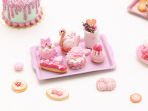 Beautiful presentation of pink miniature French pastries and treats (swan, éclair, religieuse)