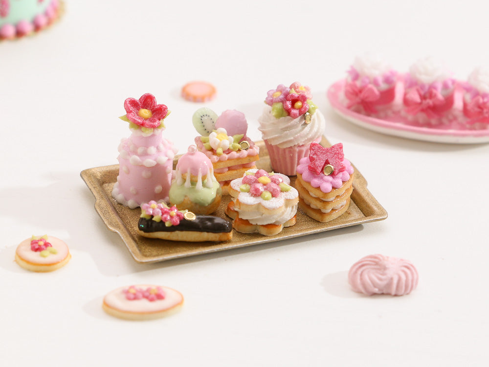 Beautiful presentation of pink miniature French pastries and treats on gold tray – Miniature Food