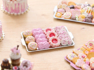 A miniature metal tray filled with handmade miniature food sweet treats including meringues in pink made from polymer clay