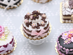 Cream Cake Decorated with Chocolate Palets, Bows, Blossoms and Macaron - Miniature Food