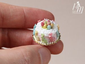Miniature Easter Cake Decorated with Colourful Bunnies and Eggs in White Cream Nest